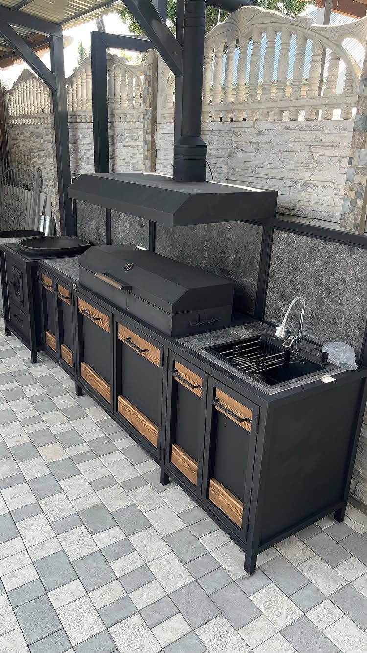 10 Foot Outdoor Kitchen: 5 Plans That Actually Fit the Space 5 Black outdoor kitchen unit with a built-in grill, sink, and wooden cabinet doors on a tiled patio.