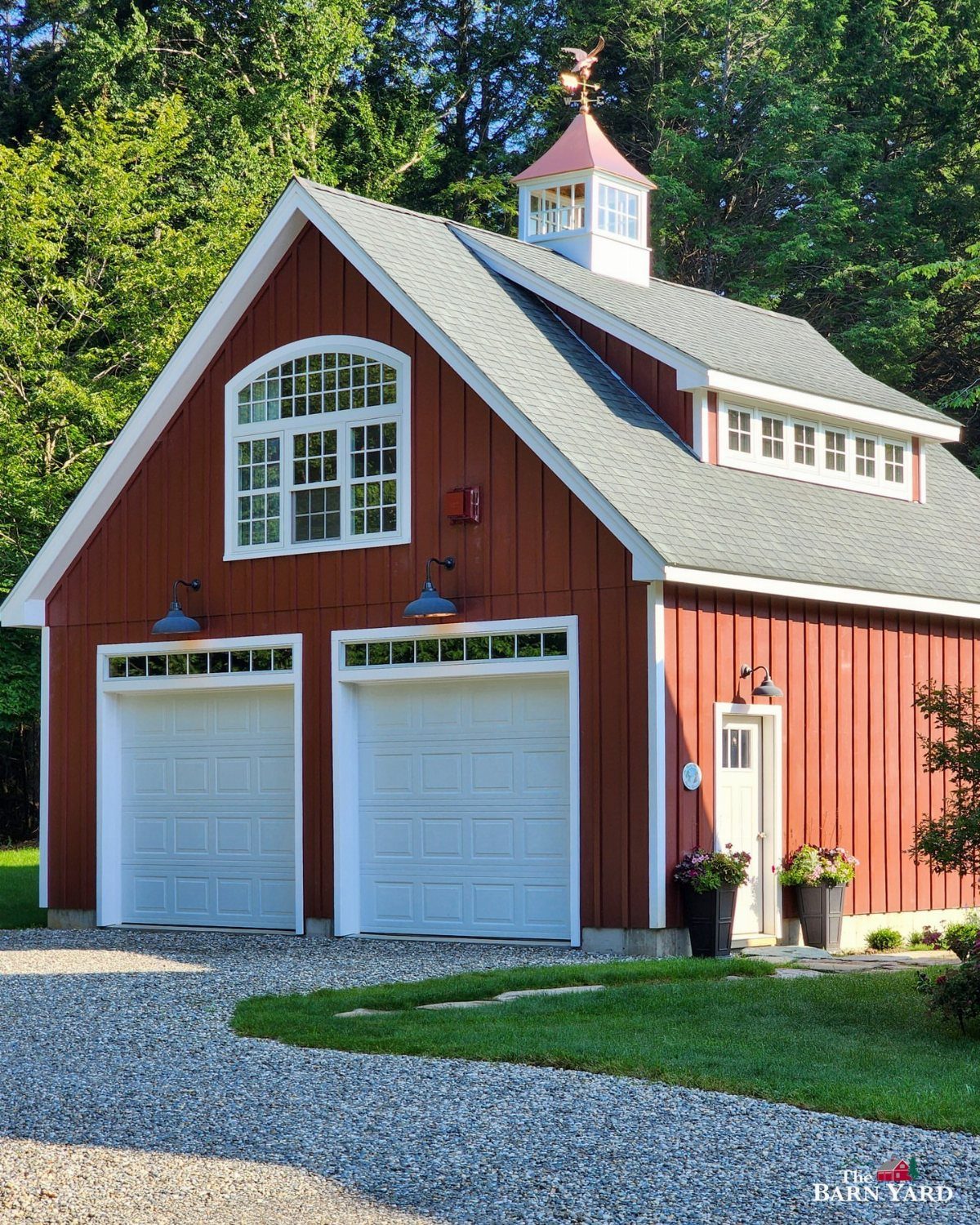 Red two-story garage building with white doors and living quarters windows above.