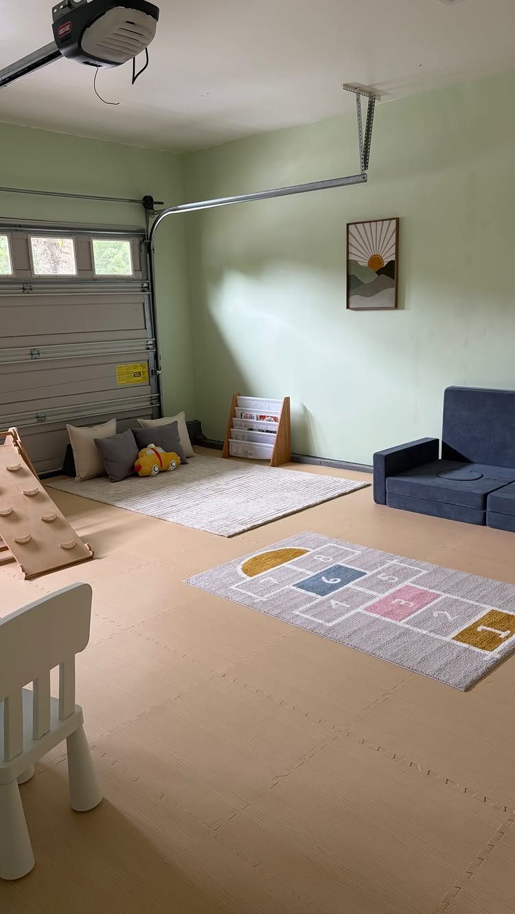 2 Car Garage Makeover Ideas: 8 Projects for a Finished Space 8 A garage converted into a playroom with floor mats, rugs, a climbing toy, and a small sofa.