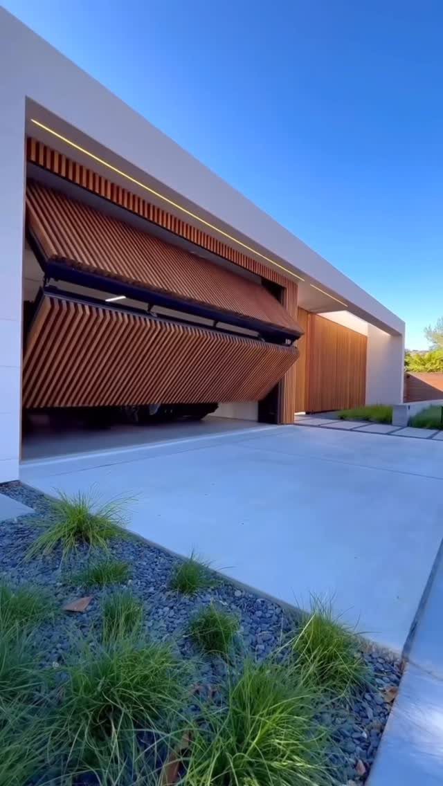 2 Car Garage Makeover Ideas: 8 Projects for a Finished Space 5 Modern white house with a unique wooden slat garage door partially open above a concrete driveway.