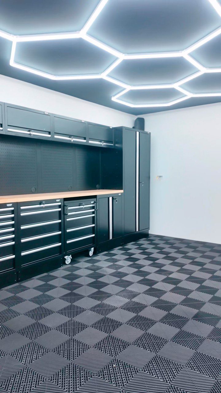 2 Car Garage Makeover Ideas: 8 Projects for a Finished Space 1 Black metal garage storage cabinets and tool chests installed against a white wall with patterned flooring.