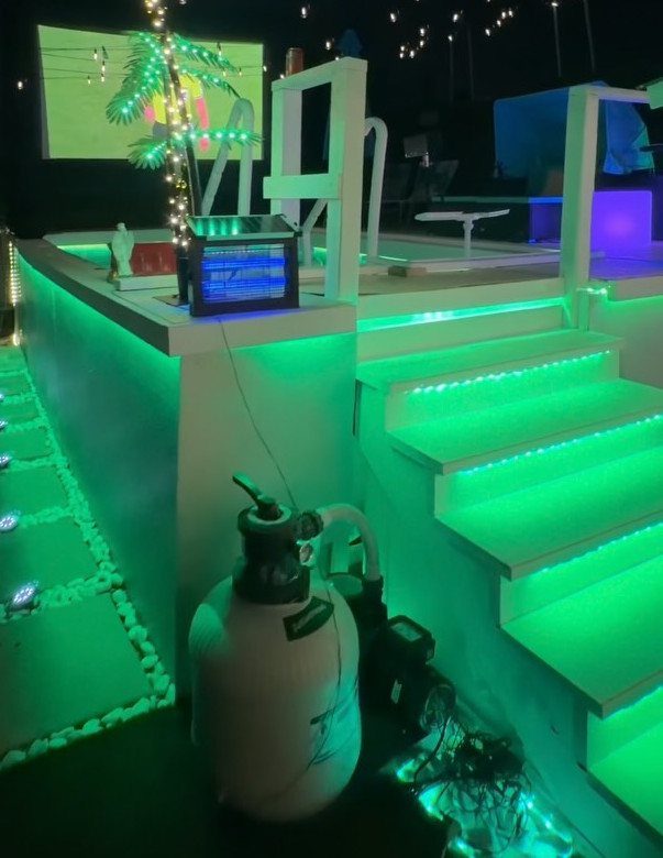 White pool deck steps illuminated by vibrant green LED strip lights at night.