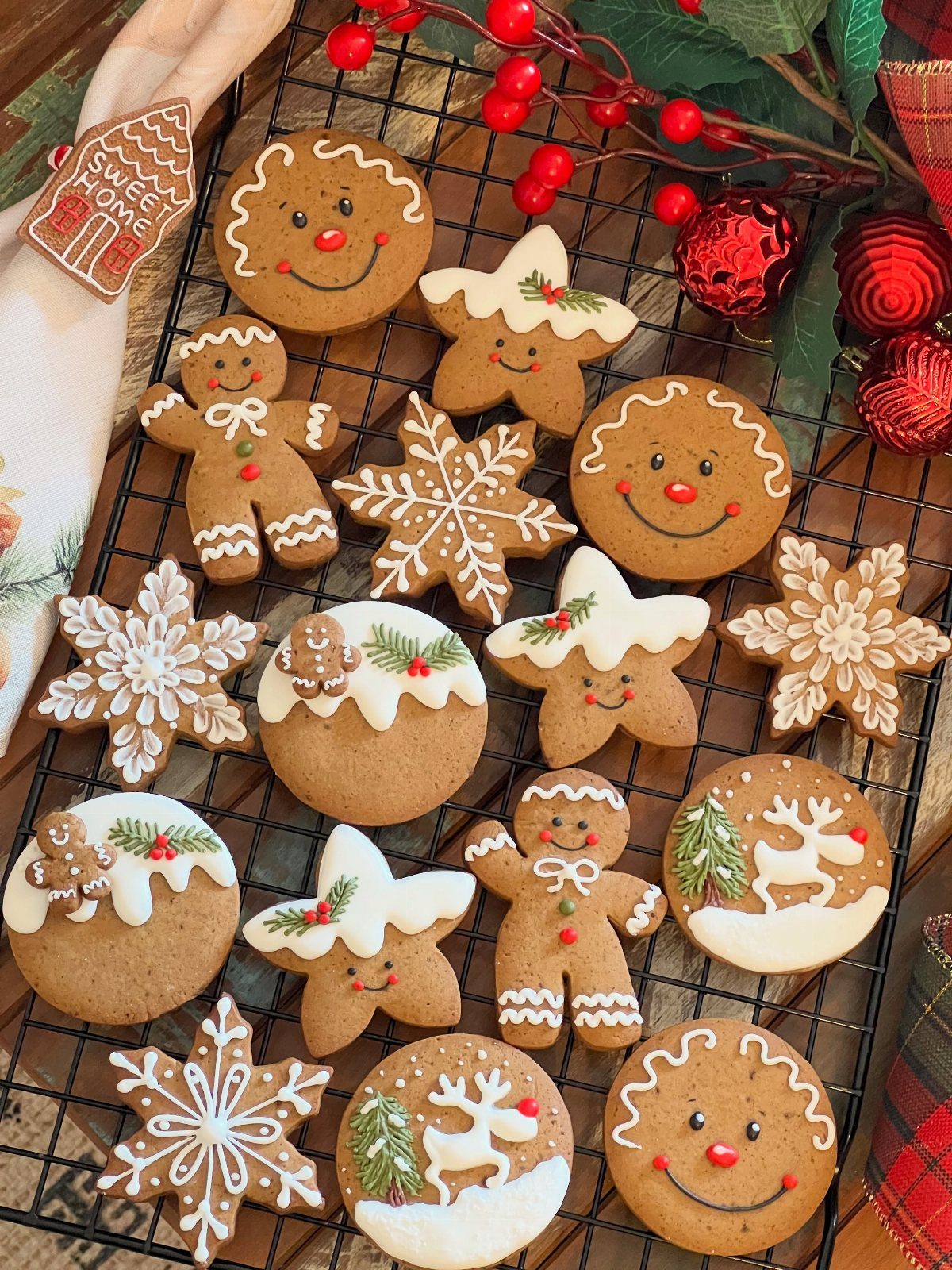 Decorated gingerbread cookies in various festive shapes resting on a black wire cooling rack.