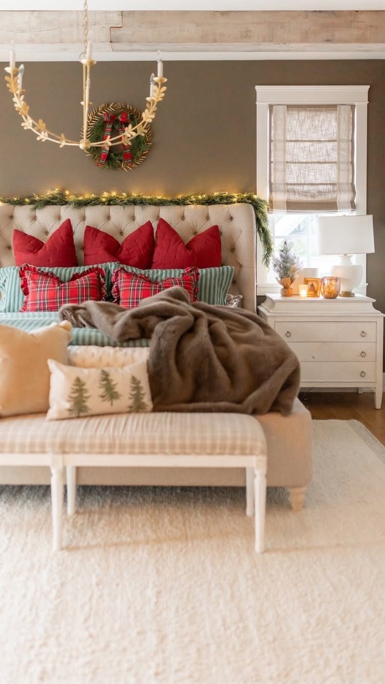 Red plaid and pine tree patterned pillows sit on a bed with a brown fur throw.