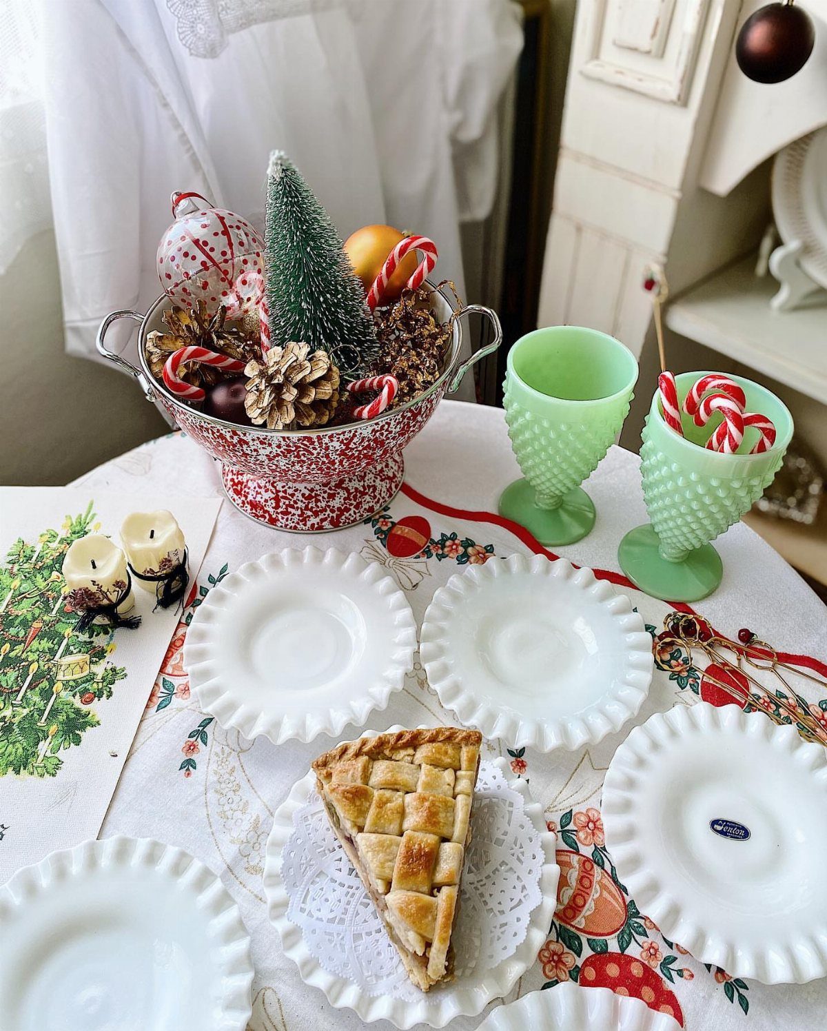 Christmas Table Centerpieces: 8 Ideas for Holiday Tables 4 A red colander centerpiece filled with a small tree, pinecones, and candy canes on a table.