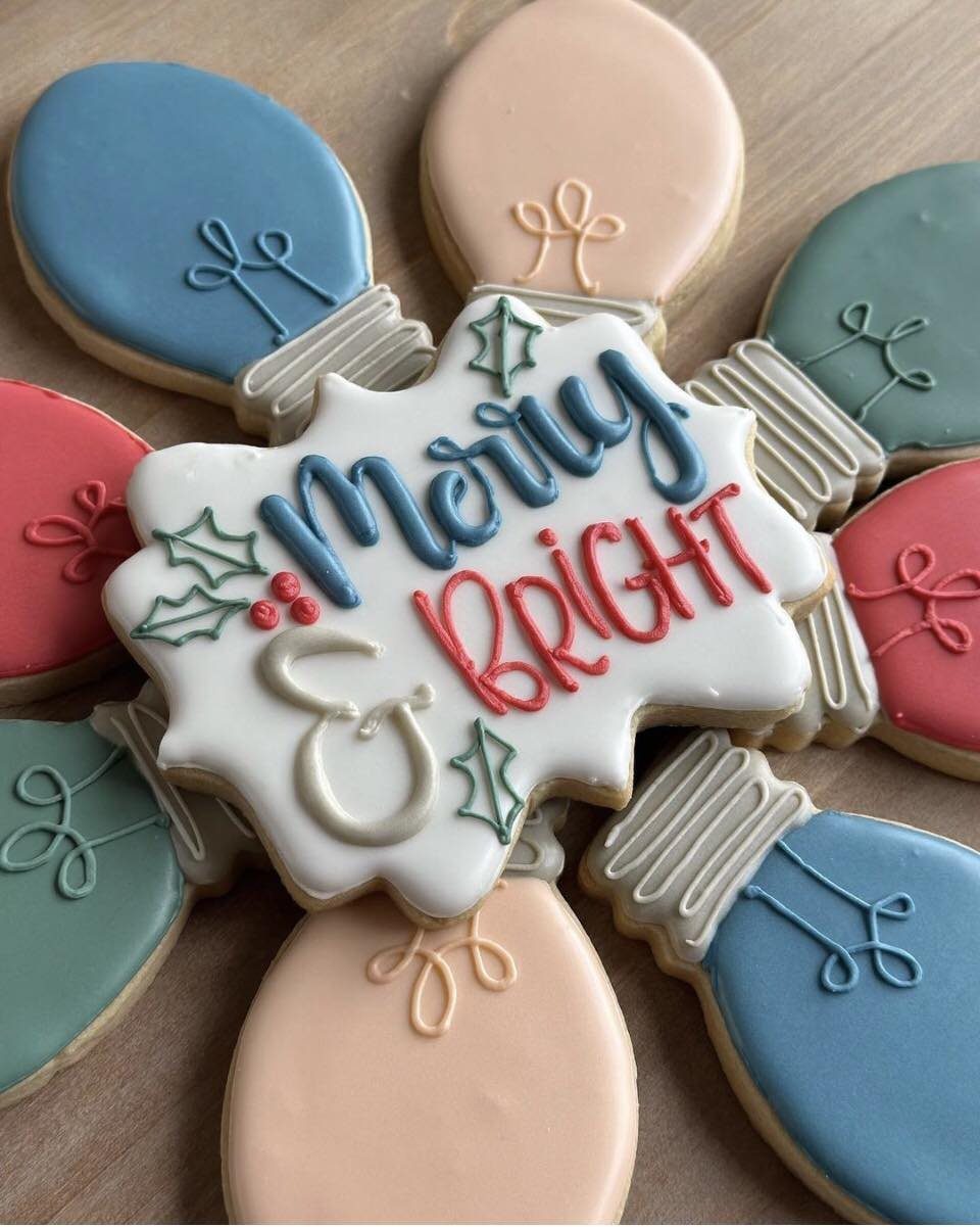 Light bulb shaped sugar cookies arranged around a central Merry and Bright decorated cookie.