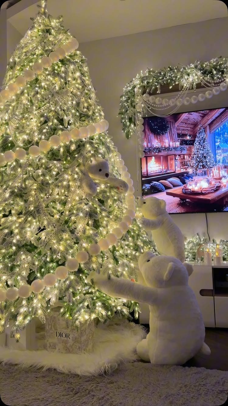 A glowing Christmas tree decorated with white lights, bead garlands, and large white teddy bear ornaments.