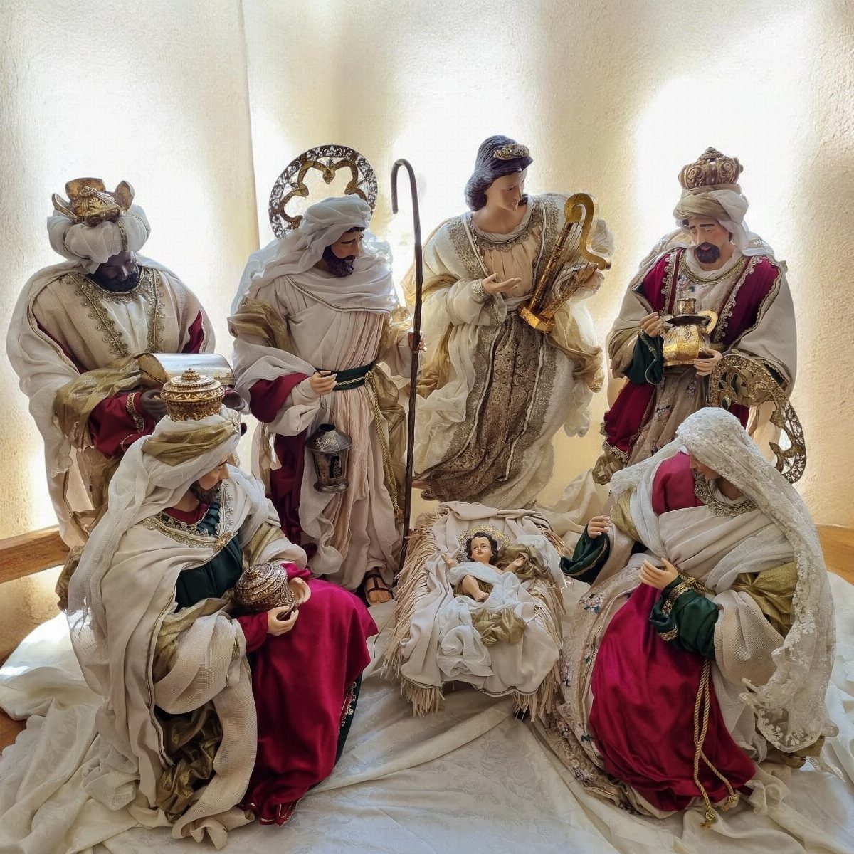 A detailed nativity scene with figures in traditional robes surrounding the baby Jesus in a manger.