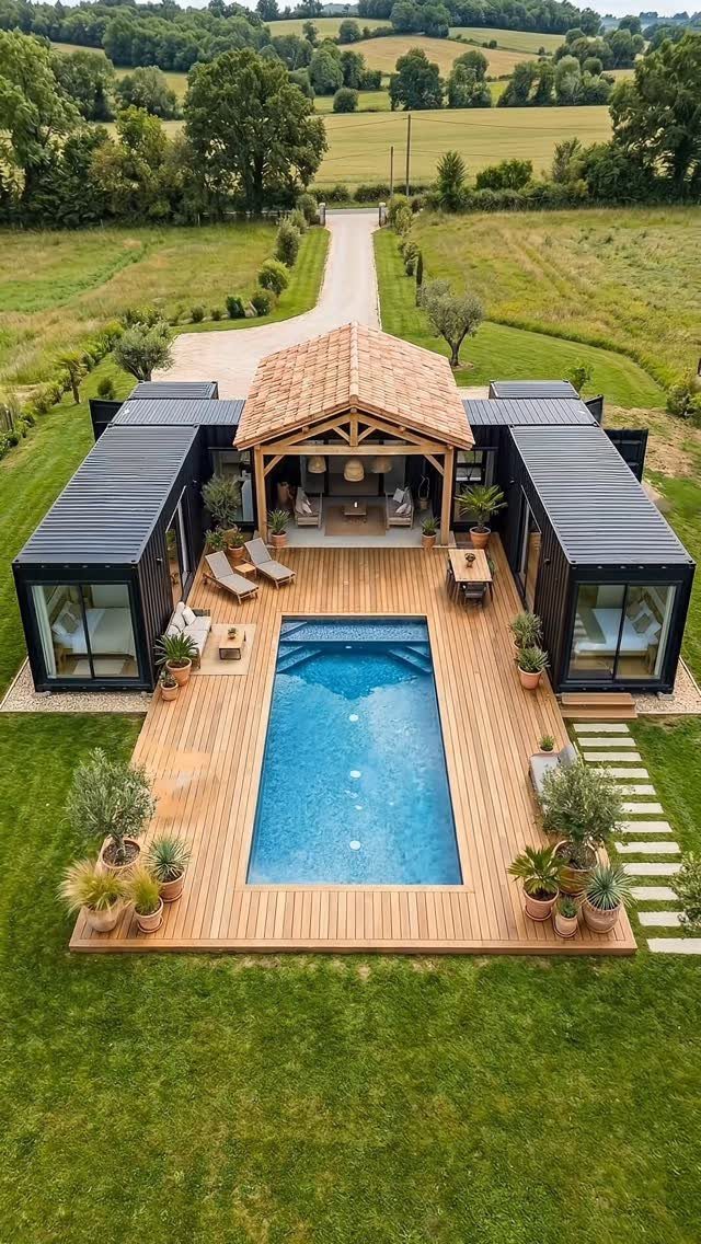 Aerial view of a modern swimming pool surrounded by a wooden deck and a timber pool pavilion.
