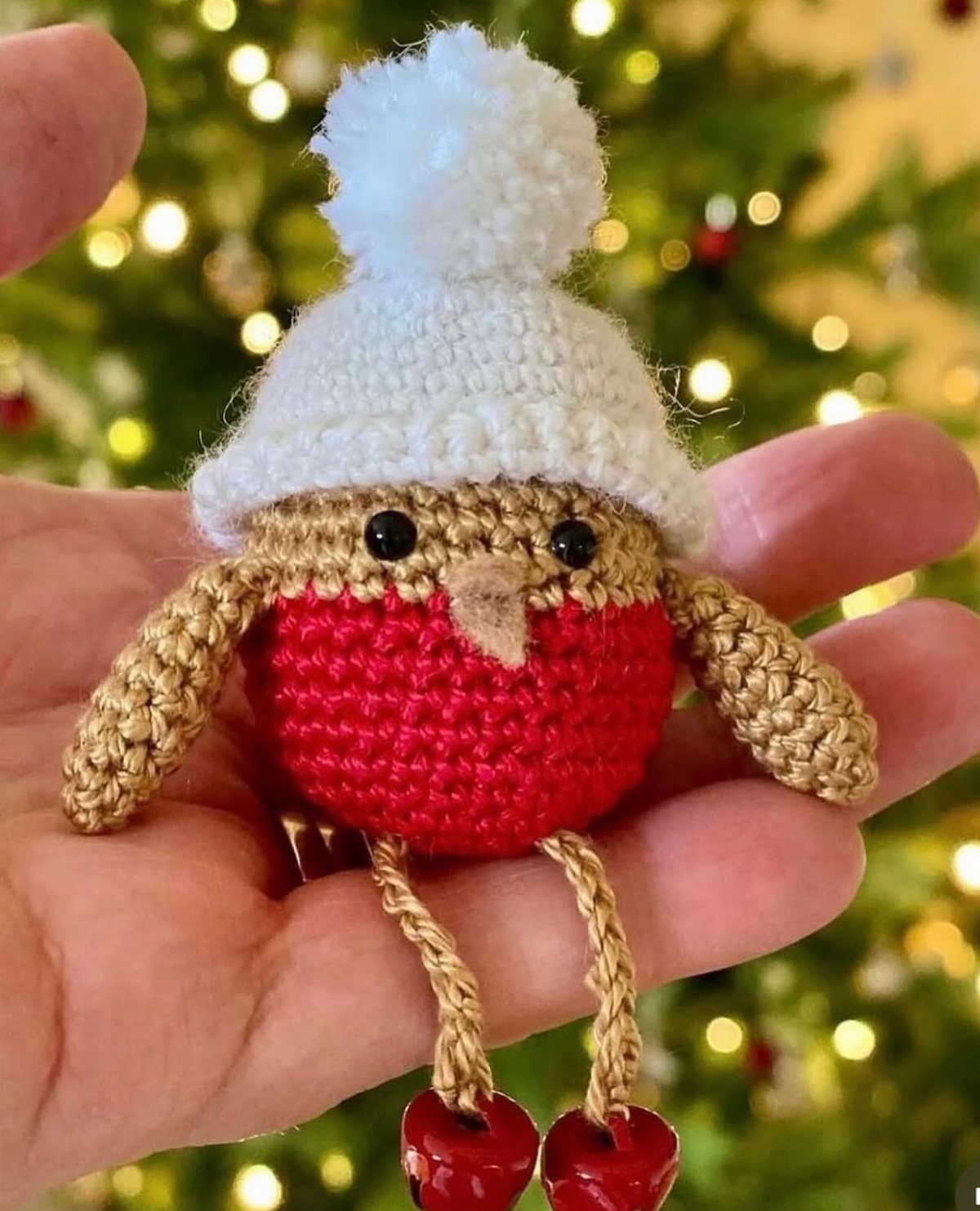 Crochet Christmas Ornaments: 19 Free Patterns for 2026 16 A small crocheted robin ornament with a white hat held in a person's hand.