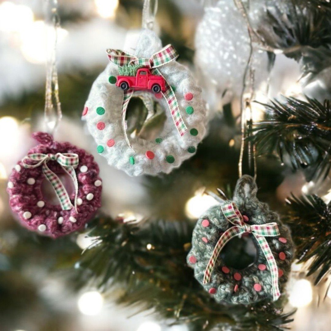 Crochet Christmas Ornaments: 19 Free Patterns for 2026 1 Three crocheted wreath ornaments with tiny bows hanging on a decorated Christmas tree.