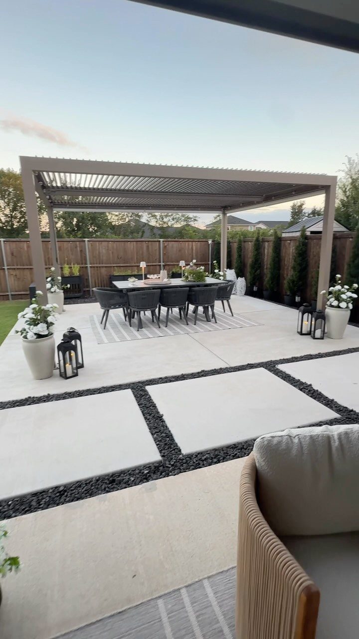 Decorating a Patio: 10 Ideas for a Space You Actually Use 8 A dark outdoor dining set with chairs sits under a large pergola on a modern patio.