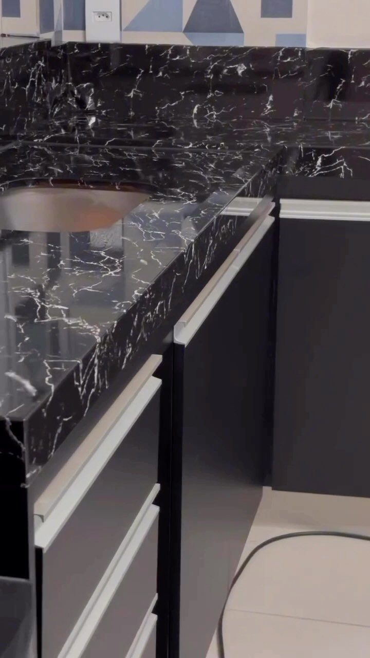 6 DIY Kitchen Countertops That Cost Less Than You Expect 6 Black marble-patterned kitchen countertop with white veins installed on dark grey and white cabinets.