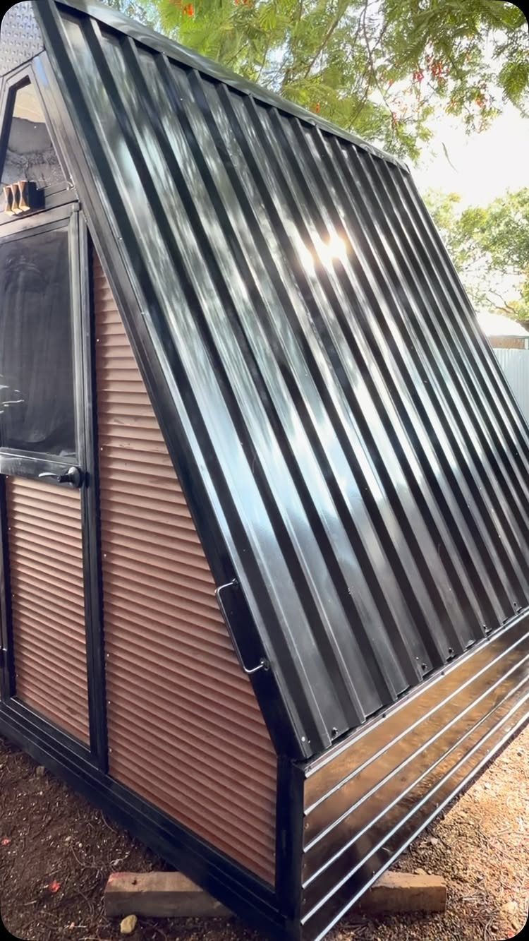 DIY Modern Shed: 19 Plans for Every Yard and Budget 15 A modern small shed with a black corrugated metal roof and copper-toned siding.