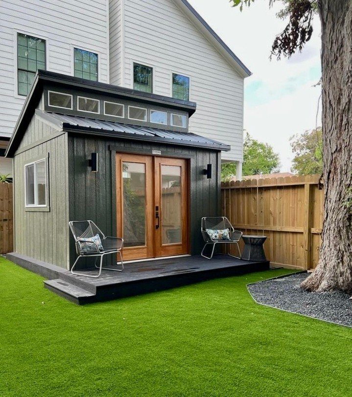 DIY Modern Shed: 19 Plans for Every Yard and Budget 17 Modern dark green shed with wooden doors and black metal roof on a manicured lawn.