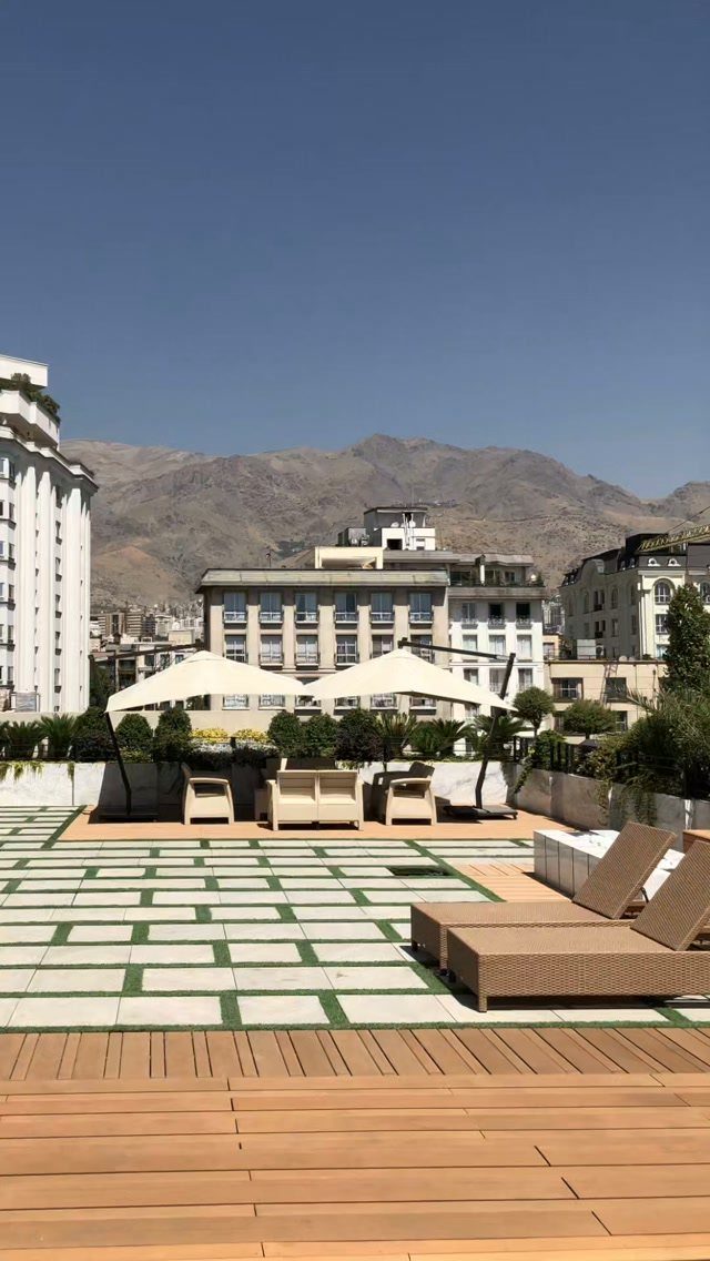 11 Elevated Deck Ideas: Multi-Level Looks, Storage & Rooftop Builds 7 Rooftop terrace with wooden decking, lounge furniture, and mountains in the background.