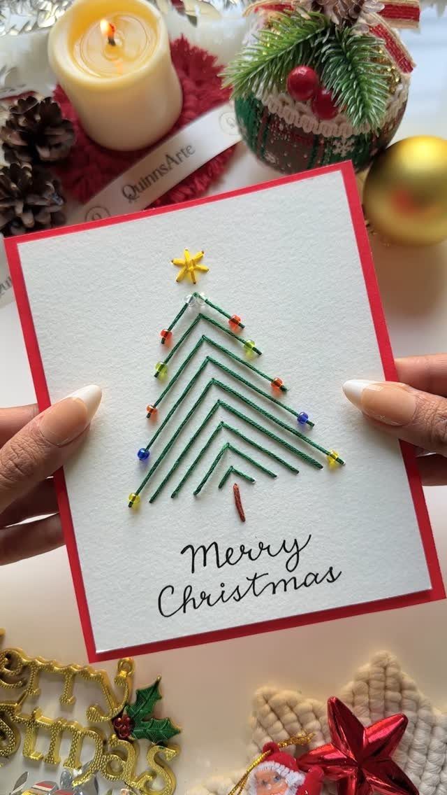Fun Christmas Activities for Families: 18 Ideas With Photos 3 Hands holding a handmade Christmas card featuring an embroidered green tree with colorful bead ornaments.