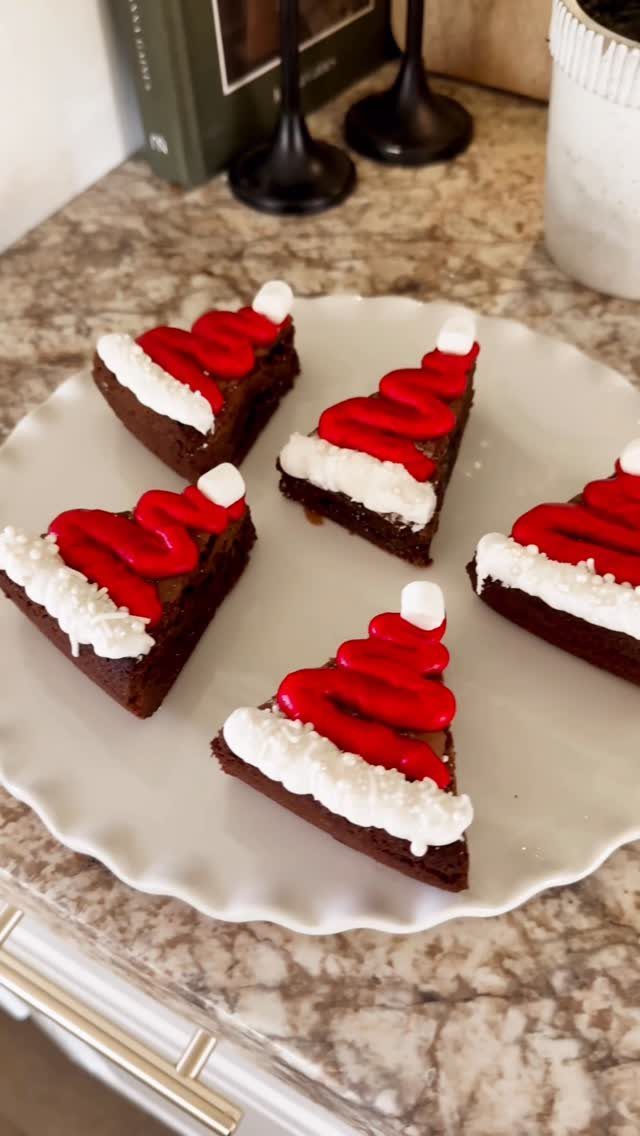 Fun Christmas Activities for Families: 18 Ideas With Photos 17 Six chocolate brownies decorated with red and white frosting to look like Santa hats on a plate.