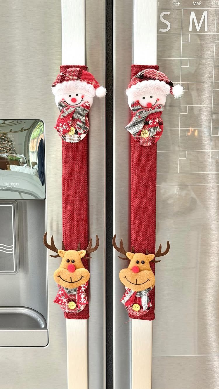 Felt snowman and reindeer decorations attached to red fabric strips on refrigerator handles.