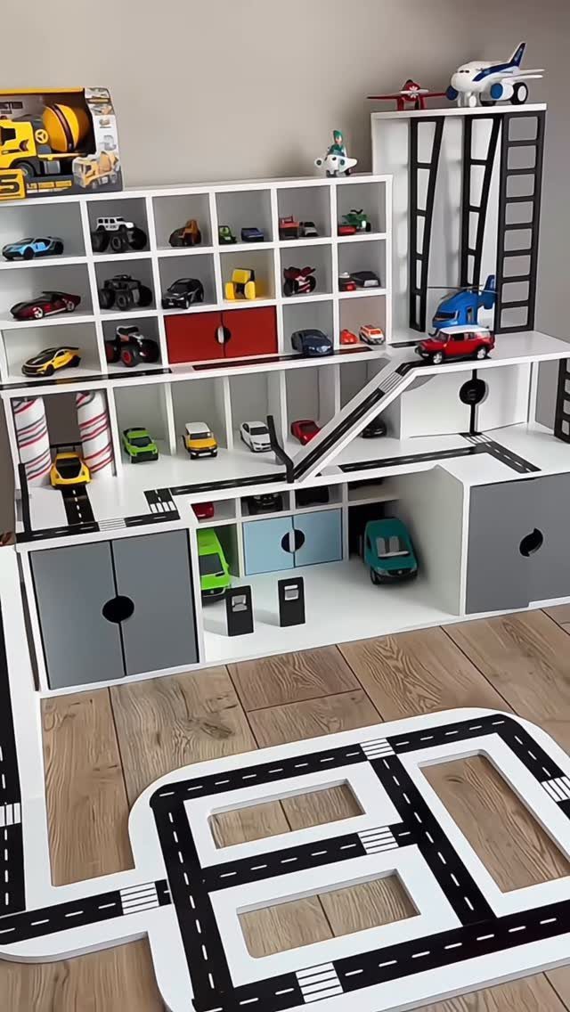 17 Garage Playroom Ideas for Safe, Creative Kid Space 16 White wooden toy garage storage unit filled with colorful miniature cars and airplanes.