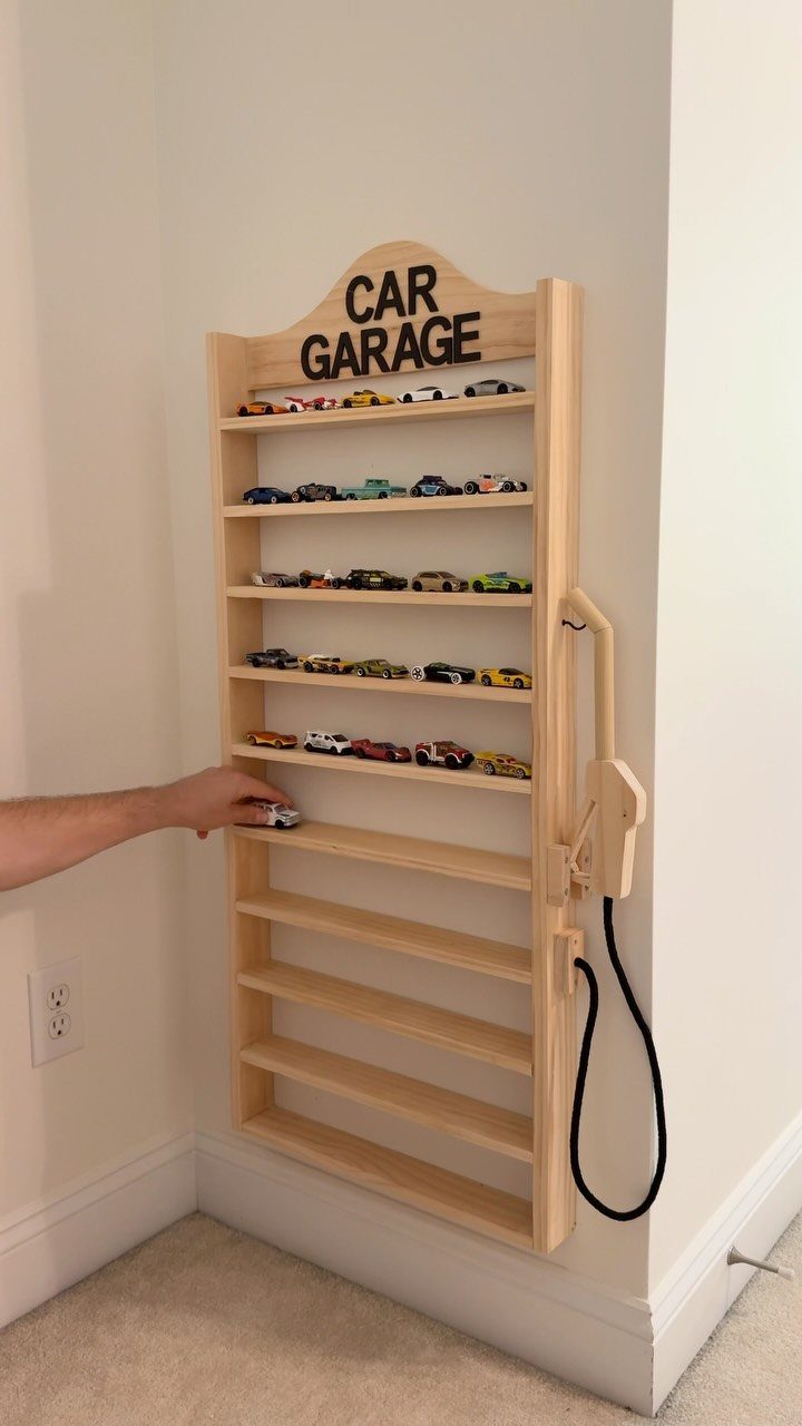 17 Garage Playroom Ideas for Safe, Creative Kid Space 6 Wooden wall-mounted toy car garage shelf being used to organize small toy cars.