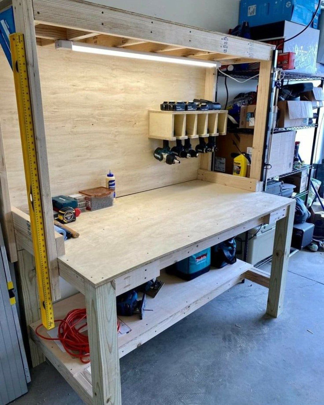 Garage Tool Setup: 8 Ideas That Actually Save Space and Time 1 A sturdy handmade wooden workbench with a plywood top and integrated overhead lighting and tool storage.