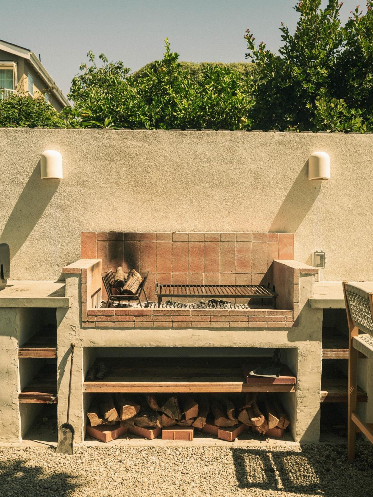 14 Outdoor Built In Grill Ideas for Every Backyard Style 9 Built-in outdoor grill station featuring a brick veneer base and wood storage underneath.