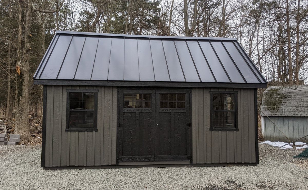 6 Painted Shed Colors for a Backyard That Actually Looks Planned 3 A two-tone garden shed with taupe siding and black doors, windows, and roof.