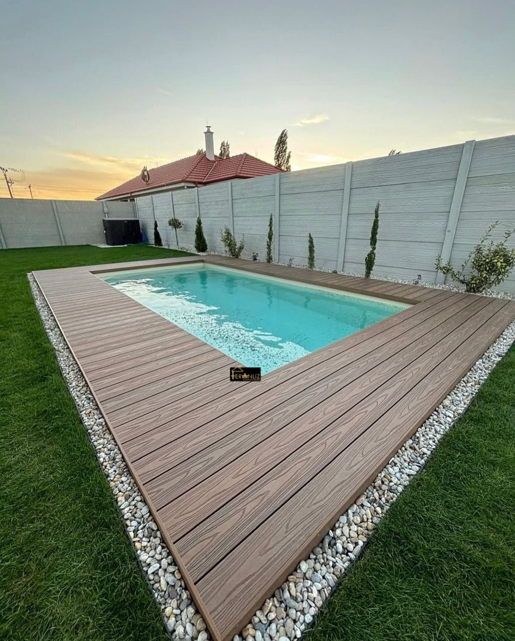 Raised Deck Frame: 8 Ideas From Wood Joists to Galvanized Steel 1 Brown wooden deck planks surrounding a bright blue swimming pool in a backyard garden.